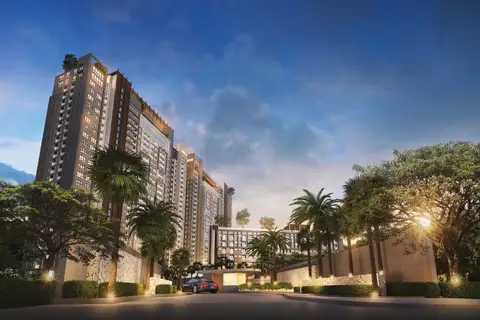 Seven Seas Le Carnival grand entrance to the condo complex, with palm trees, illuminated landscaping, and a car arriving.
