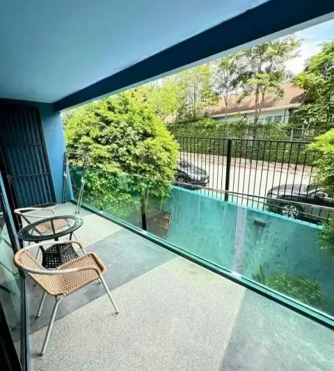 1 Bedroom Condo for Rent at Acqua Condo balcony with rattan chairs overlooking greenery