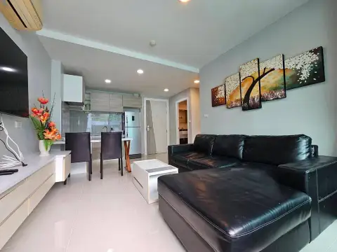 2 Bedroom Condo for Sale at Acqua Condo lounge area with leather sectional sofa and floral wall art