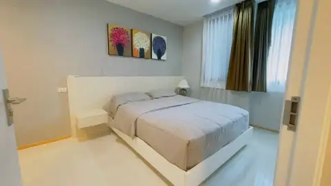 2 Bedroom Condo for Sale at Acqua Condo master bedroom with double bed and floral wall art