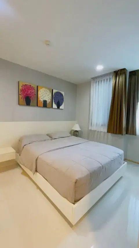2 Bedroom Condo for Sale at Acqua Condo second bedroom with white bed frame and curtained window
