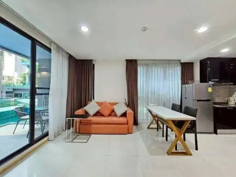 1 Bedroom Condo for Rent at Acqua Condo living space with sofa, dining table and glass balcony door