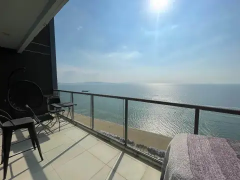 1 Bedroom Condo for Rent at Aeras balcony with hanging chair, seating, and panoramic ocean view