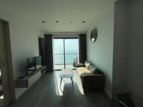 1 Bedroom Condo for Rent at Aeras living room with sofa, coffee table, and floor-to-ceiling sea view window