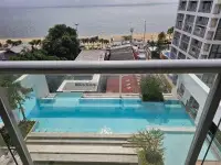 1 Bedroom Condo for Sale at Aeras view through glass balcony railing overlooking pool and sea