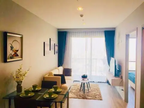 2 Bedroom Condo for Sale at Aeras open-plan living and dining area with sofa and balcony access