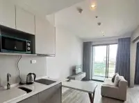 1 Bedroom Condo for Sale at Aeras living room with balcony view, sofa and kitchenette