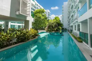 Amazon Residence long swimming pool with lush tropical landscaping and a small bridge between buildings.