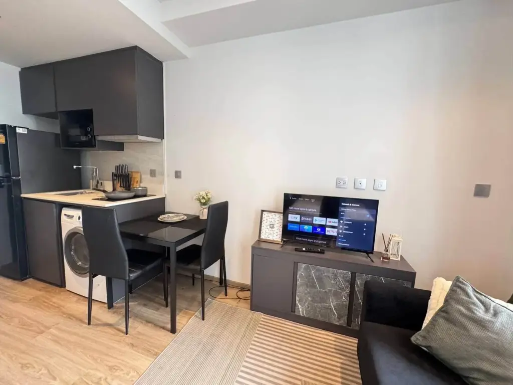 Studio Condo for Rent at Andromeda Condominium kitchenette with dining table, washing machine, and TV console
