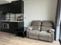 1 Bedroom Condo for Sale at Andromeda Condominium open-plan kitchen with black cabinetry and reclining loveseat sofa