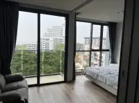 1 Bedroom Condo for Sale at Andromeda Condominium bedroom and living area with floor-to-ceiling windows overlooking city and sea