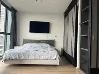 1 Bedroom Condo for Sale at Andromeda Condominium bedroom with wall-mounted TV, built-in wardrobe and wood flooring