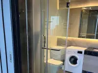 1 Bedroom Condo for Sale at Andromeda Condominium bathroom with glass shower, washing machine and marble vanity