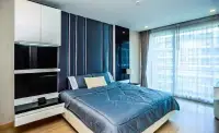 1 Bedroom Condo for Sale at Apus master bedroom with blue upholstered headboard and city view window