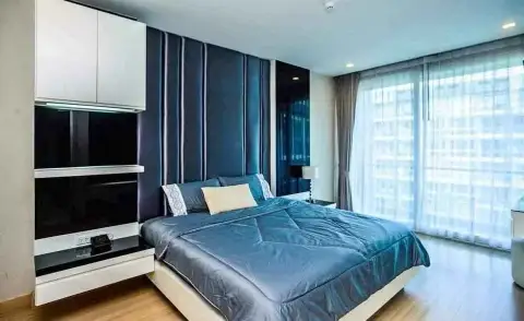 1 Bedroom Condo for Sale at Apus master bedroom with blue upholstered headboard and city view window