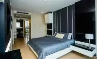 1 Bedroom Condo for Sale at Apus bedroom with wood flooring, flat-screen TV and en-suite entrance