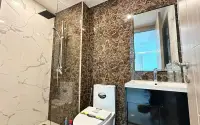 2 Bedroom Condo for Sale at Arcadia Beach Continental marble-tiled bathroom with glass rain shower and dark vanity cabinet