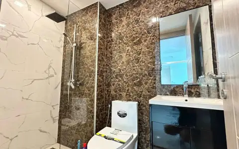 2 Bedroom Condo for Sale at Arcadia Beach Continental marble-tiled bathroom with glass rain shower and dark vanity cabinet