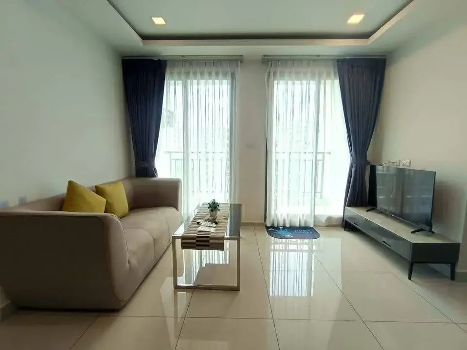 2 Bedroom Condo for Rent at Arcadia Beach Continental living room with beige sofa, yellow pillows and TV console