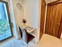 1 Bedroom Condo for Rent at Arcadia Beach Resort small balcony dining nook with wall clock and wooden doors