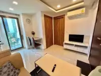 1 Bedroom Condo for Rent at Arcadia Beach Resort living area with TV stand, air conditioner, and balcony view