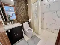 1 Bedroom Condo for Rent at Arcadia Beach Resort bathroom with marble shower, black vanity sink, and toilet