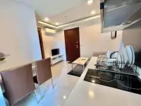 1 Bedroom Condo for Rent at Arcadia Beach Resort open kitchen with induction stove, dining chairs, and entryway