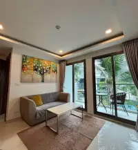 2 Bedroom Condo for Rent at Arcadia Beach Resort living room with sofa, floral art, and balcony pool view
