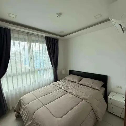2 Bedroom Condo for Rent at Arcadia Beach Resort bedroom with queen bed, dark headboard and city view window