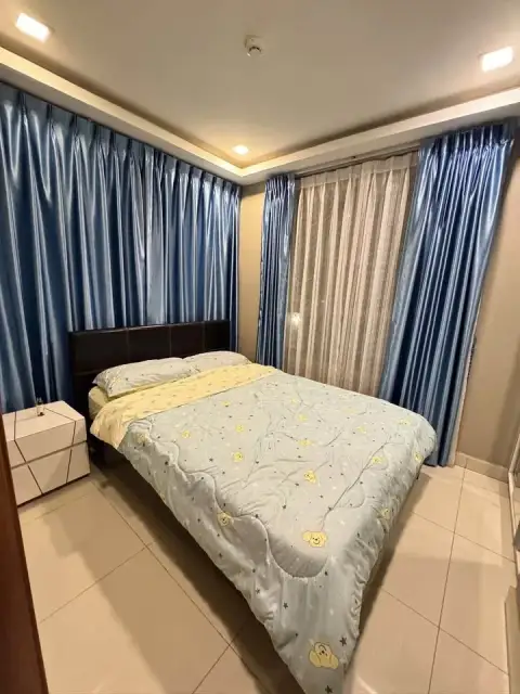 2 Bedroom Condo for Rent at Arcadia Beach Resort second bedroom with blue curtains and patterned blue bedding