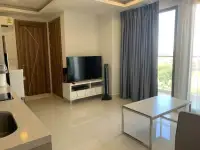 2 Bedroom Condo for Rent at Arcadia Beach Resort living area with TV stand and city view window