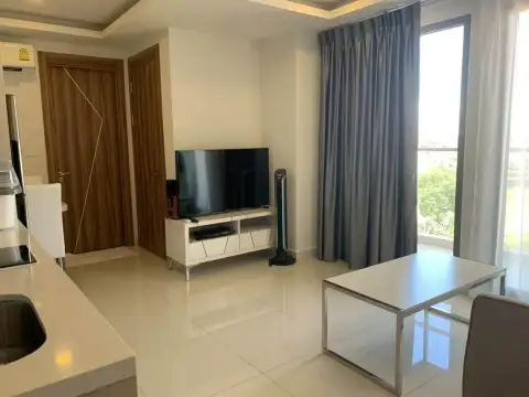 2 Bedroom Condo for Rent at Arcadia Beach Resort living area with TV stand and city view window