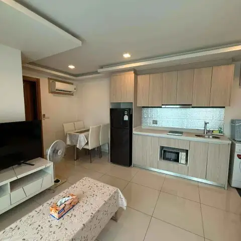 2 Bedroom Condo for Rent at Arcadia Beach Resort kitchen and dining area with TV and fan in open layout