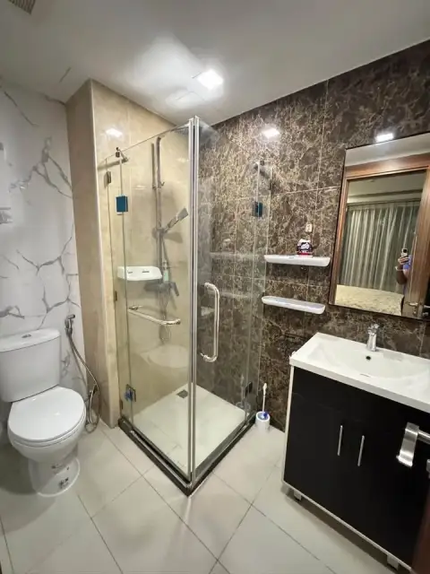 2 Bedroom Condo for Rent at Arcadia Beach Resort bathroom with glass-enclosed shower, marble tile, and vanity sink