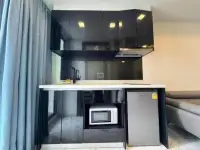 1 Bedroom Condo for Sale at Arcadia Millennium Tower kitchenette with black cabinets, microwave and mini fridge