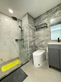 1 Bedroom Condo for Sale at Arcadia Millennium Tower bathroom with glass shower and marble tile walls