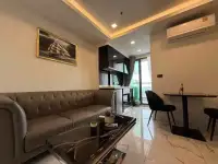 1 Bedroom Condo for Rent at Arcadia Millennium Tower living space with sofa, kitchenette and balcony view