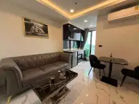1 Bedroom Condo for Rent at Arcadia Millennium Tower living room with leather sofa, marble coffee table and open kitchen