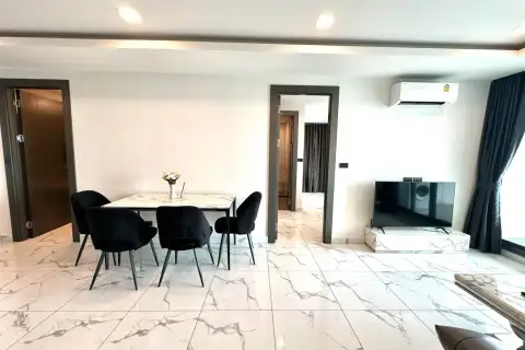 2 Bedroom Condo for Rent at Arcadia Millennium Tower dining area with black chairs, marble table and wall-mounted TV
