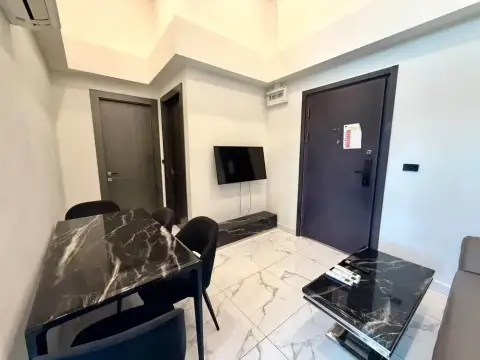 2 Bedroom Condo for Rent at Arcadia Millennium Tower entryway with wall-mounted TV, marble dining table, and front door