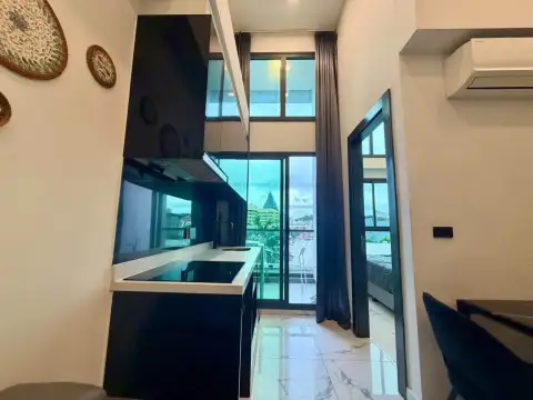 2 Bedroom Condo for Rent at Arcadia Millennium Tower kitchen with black cabinetry, induction stove, and balcony view