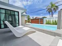 3 Bedroom House for Sale at Areeya Villa poolside patio with white lounge chairs and palm tree backdrop