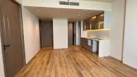 2 Bedroom Condo for Sale at Arom Jomtien open-plan living area with kitchen cabinets and wood flooring