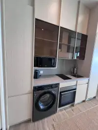 1 Bedroom Condo for Sale at Arom Wongamat compact kitchenette with built-in oven and washing machine