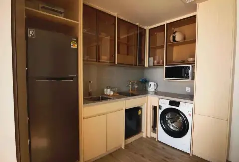 1 Bedroom Condo for Sale at Arom Wongamat kitchenette with fridge, washing machine and wood cabinetry