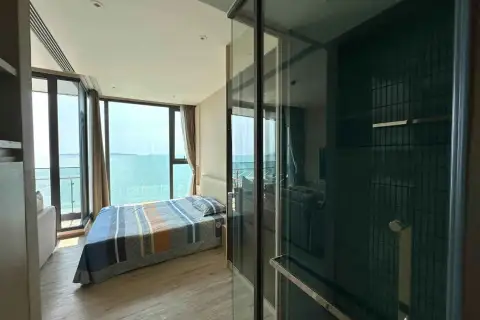 1 Bedroom Condo for Rent at Arom Wongamat bedroom with ocean view and glass-enclosed bathroom