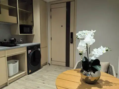 1 Bedroom Condo for Sale at Arom Wongamat compact kitchenette with washer, microwave and entry door