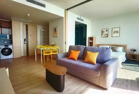 1 Bedroom Condo for Sale at Arom Wongamat open-plan living area with sofa, dining set and bed nook