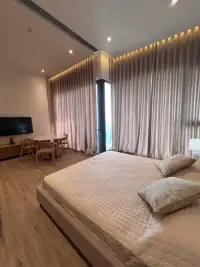 1 Bedroom Condo for Sale at Arom Wongamat bedroom with king bed, dining nook and curtained windows