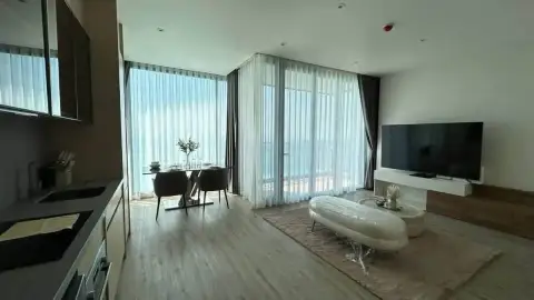2 Bedroom Condo for Rent at Arom Wongamat open-plan living room, kitchen counter and ocean view windows